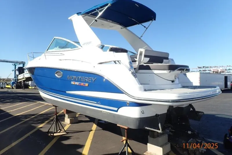 Slide: The Image of 2021 Monterey 295 Sport Yacht in blue and white, docked on stands. - 2