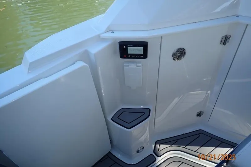 Slide: The Image of 2021 Monterey 295 Sport Yacht on stands, blue and white hull, parked outdoors. - 21