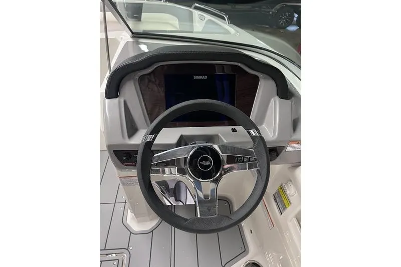 Slide: The Image of Steering wheel and dashboard of 2025 Chaparral 23 SSi boat, featuring Simrad display. - 10
