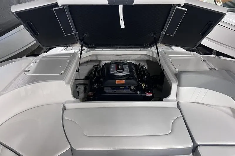Slide: The Image of 2025 Chaparral 23 SSi boat engine compartment with open hatch, showcasing engine details. - 18