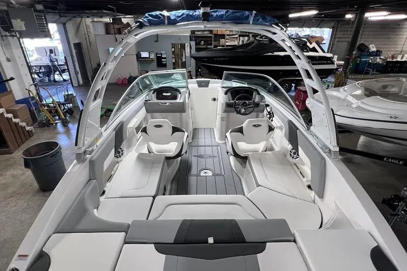 Slide: The Image of 2025 Chaparral 23 SSi boat interior with sleek seating and modern design in a showroom. - 23