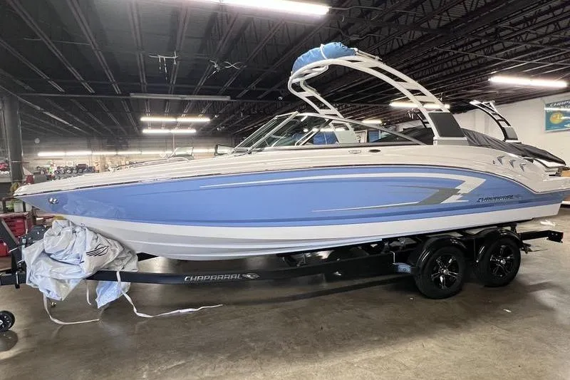 Slide: The Image of 2025 Chaparral 23 SSi boat in showroom, featuring sleek blue and white design. - 3