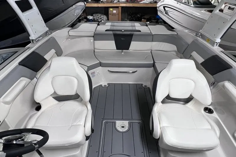 Slide: The Image of 2025 Chaparral 23 SSi boat interior with white seating and gray flooring. - 6