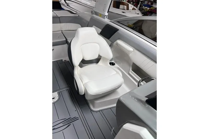 Slide: The Image of 2025 Chaparral 23 SSi boat interior with white captain's chair and sleek design. - 7