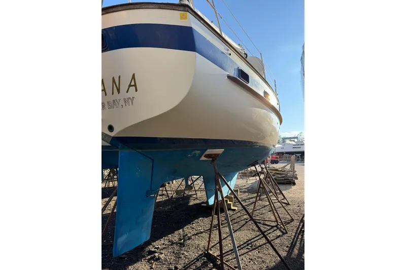 Slide: The Image of 1987 Irwin 38 Mk II sailboat on stands, hull painted blue and white. - 15