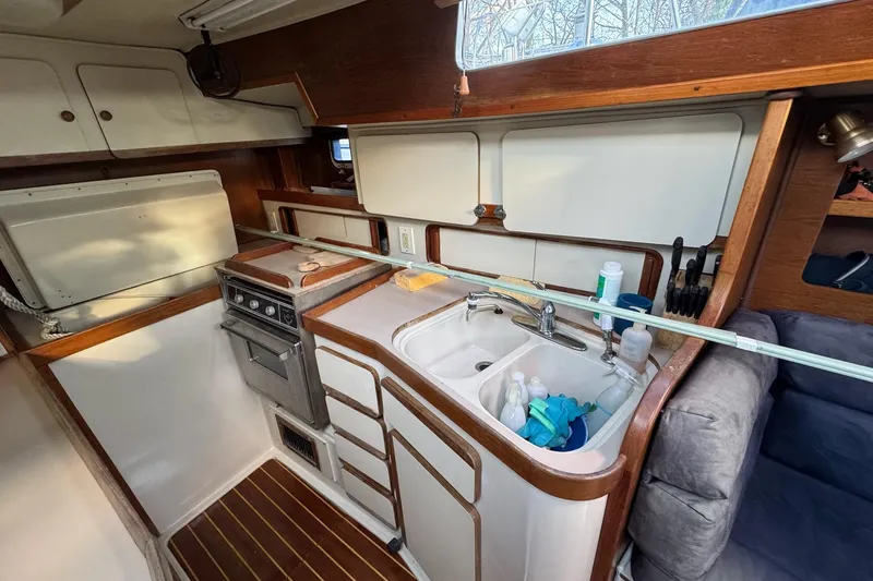 Slide: The Image of 1987 Irwin 38 Mk II yacht kitchen with stove, sink, and wooden cabinetry. - 17