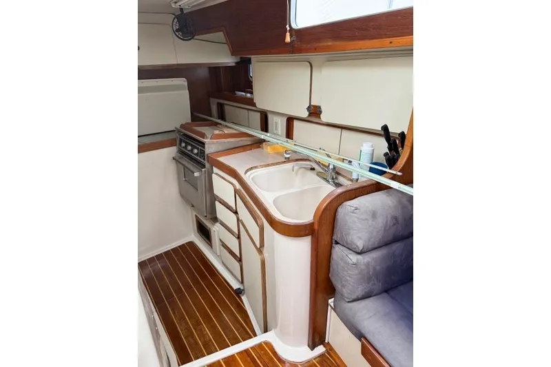 Slide: The Image of 1987 Irwin 38 Mk II yacht interior with kitchen, sink, stove, and wooden flooring. - 22