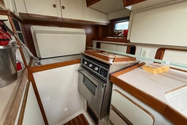 Slide: The Image of 1987 Irwin 38 Mk II yacht kitchen with stove, cabinets, and wooden accents. - 23