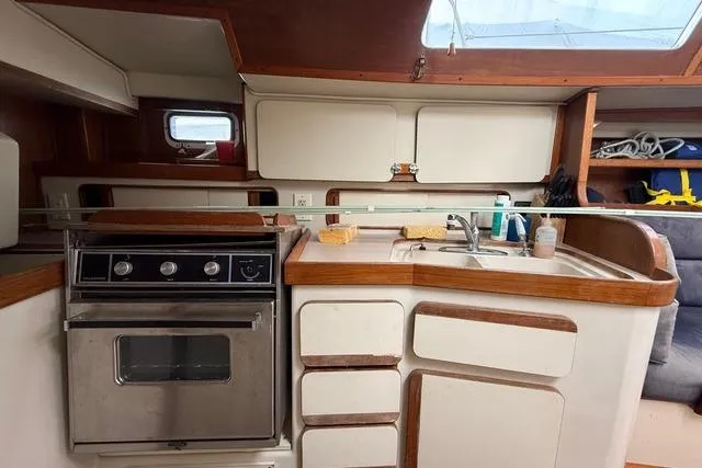 Slide: The Image of 1987 Irwin 38 Mk II yacht kitchen with stove, sink, and storage cabinets. - 24