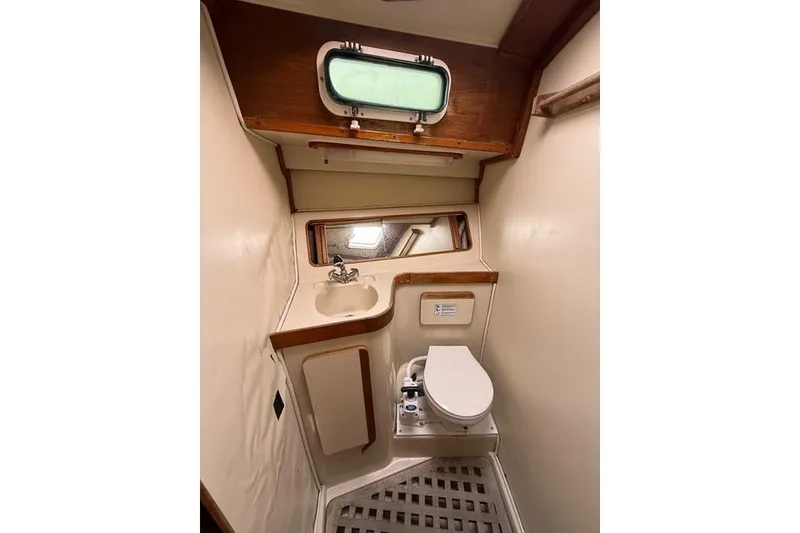 Slide: The Image of 1987 Irwin 38 Mk II yacht bathroom with sink, toilet, and porthole window. - 40