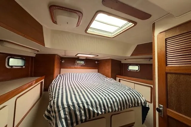 Slide: The Image of Cozy cabin interior of 1987 Irwin 38 Mk II sailboat with striped bedding. - 42