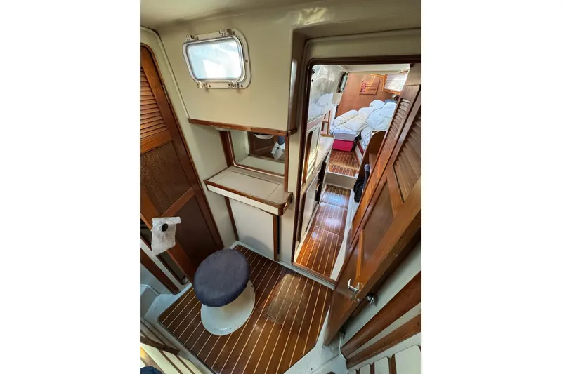 Slide: The Image of Interior of 1987 Irwin 38 Mk II sailboat, featuring wooden flooring and cozy cabin space. - 46