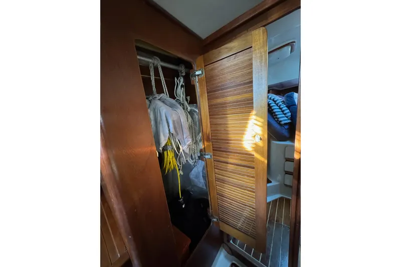 Slide: The Image of 1987 Irwin 38 Mk II sailboat interior closet with wooden door and hanging ropes. - 48