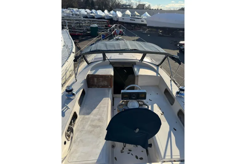 Slide: The Image of 1987 Irwin 38 Mk II sailboat cockpit with canopy, docked in a marina. - 8