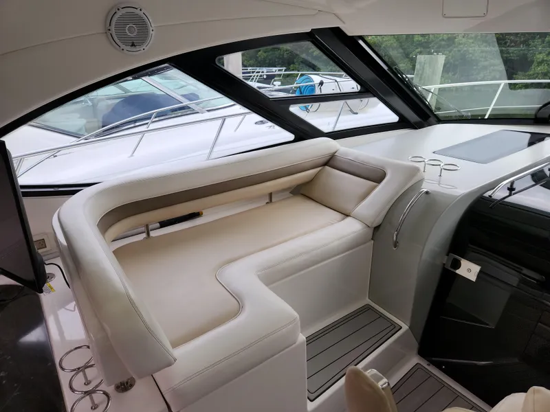 Slide: The Image of Interior seating of 2014 Sea Ray 470 Sundancer yacht, featuring luxurious beige upholstery. - 22