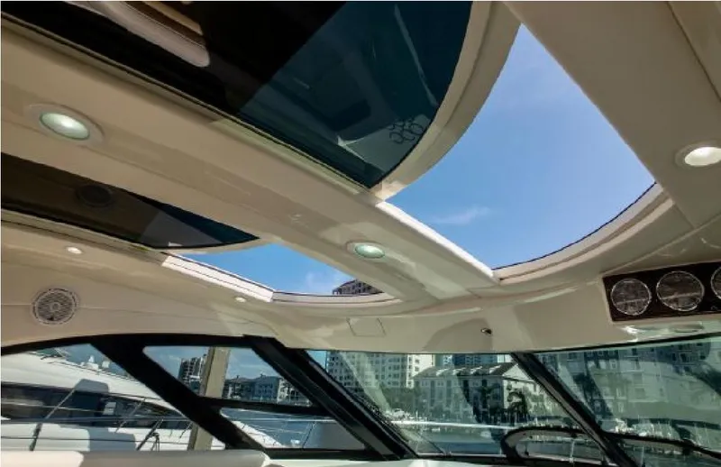 Slide: The Image of Interior view of 2014 Sea Ray 470 Sundancer yacht with sunroof and cityscape background. - 25