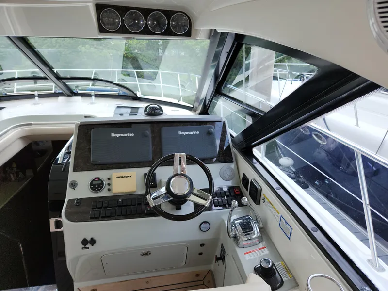 Slide: The Image of Helm of 2014 Sea Ray 470 Sundancer with modern navigation equipment and steering wheel. - 27