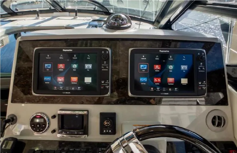 Slide: The Image of 2014 Sea Ray 470 Sundancer helm with dual Raymarine displays and modern navigation controls. - 30