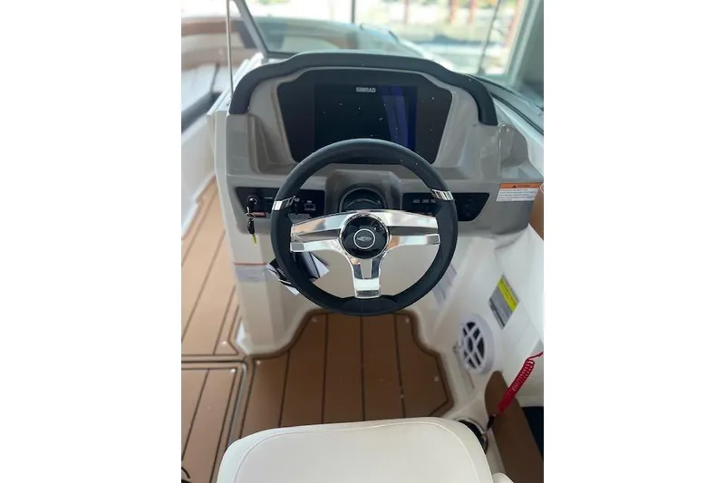 Slide: The Image of 2025 Chaparral 21 SSi boat dashboard with steering wheel and control panel. - 13