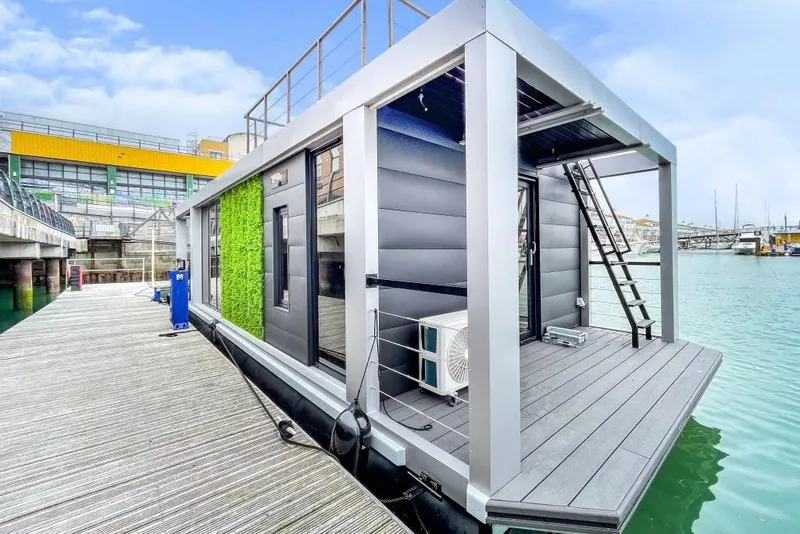 Slide: The Image of Modern Waterlodge 11 houseboat docked, featuring sleek design and rooftop access, 2026 model. - 1