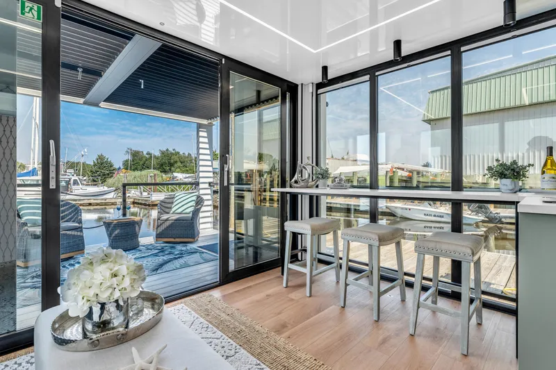 Slide: The Image of Modern Waterlodge 11 interior with large windows, stylish seating, and waterfront views, 2025 model. - 15