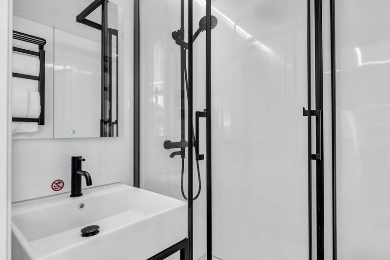 Slide: The Image of Modern bathroom in Waterlodge Modern 11, 2025 model, featuring sleek black fixtures and glass shower. - 17