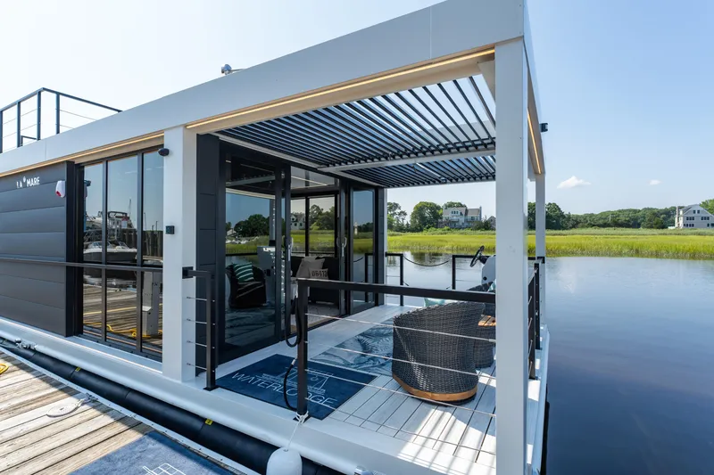 Slide: The Image of Modern Waterlodge 11 houseboat, 2025 model, with sleek design and outdoor seating on a serene lake. - 2