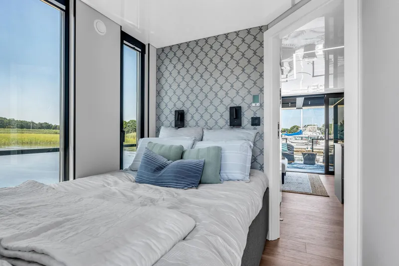 Slide: The Image of Modern Waterlodge 11 bedroom with scenic water views, stylish decor, and cozy bedding, 2025 model. - 20