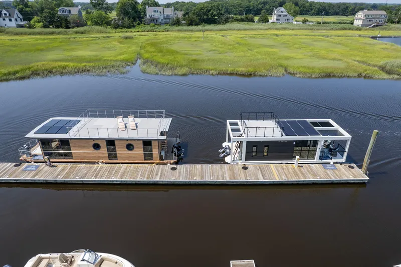 Slide: The Image of Modern Waterlodge 11 houseboats docked on a serene river, surrounded by lush greenery. - 28