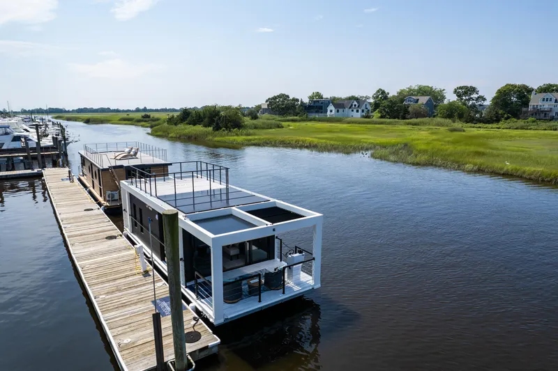 Slide: The Image of Modern Waterlodge 11 houseboat docked on a serene river, surrounded by lush greenery. - 3