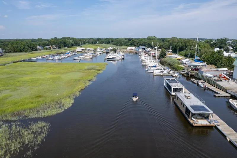 Slide: The Image of Aerial view of marina with Waterlodge Modern 11 houseboats, 2025 model, docked along the river. - 30