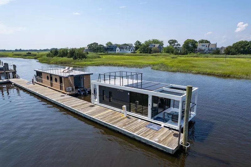 Slide: The Image of Modern Waterlodge 11 houseboat docked on a serene river, surrounded by lush greenery. - 31
