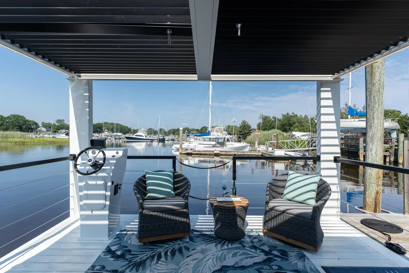 Slide: The Image of Modern Waterlodge 11 houseboat with cozy seating, overlooking a serene marina view. - 4