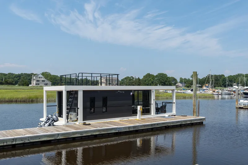 Slide: The Image of Modern Waterlodge 11 houseboat docked on a serene river, surrounded by lush greenery. - 6