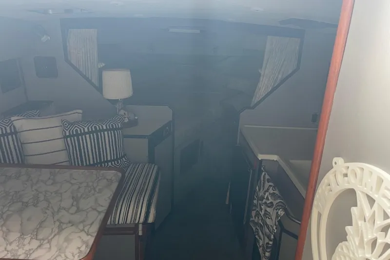 Slide: The Image of Interior of 1988 Sea Ray 300 Weekender with striped cushions and marble-patterned table. - 19