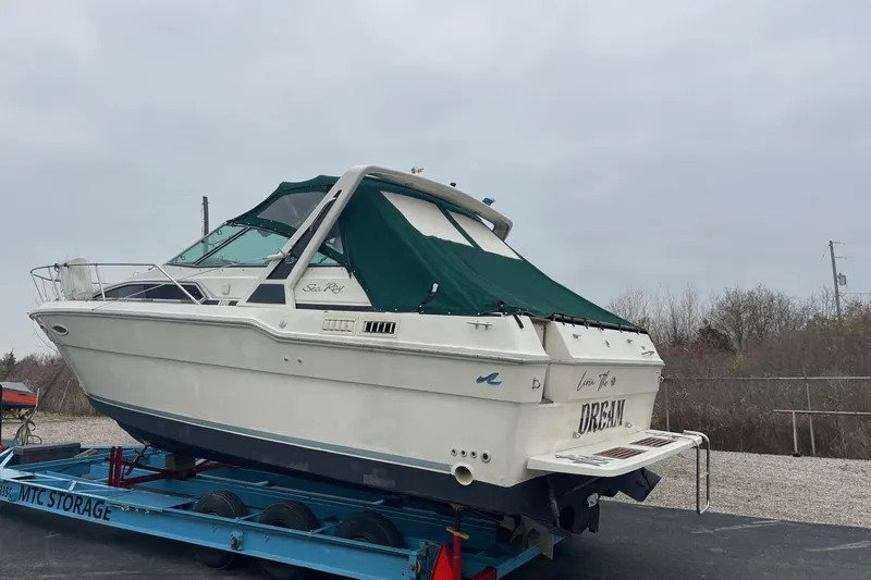 Slide: The Image of 1988 Sea Ray 300 Weekender boat with green cover, "Livin' the Dream" text on stern. - 2
