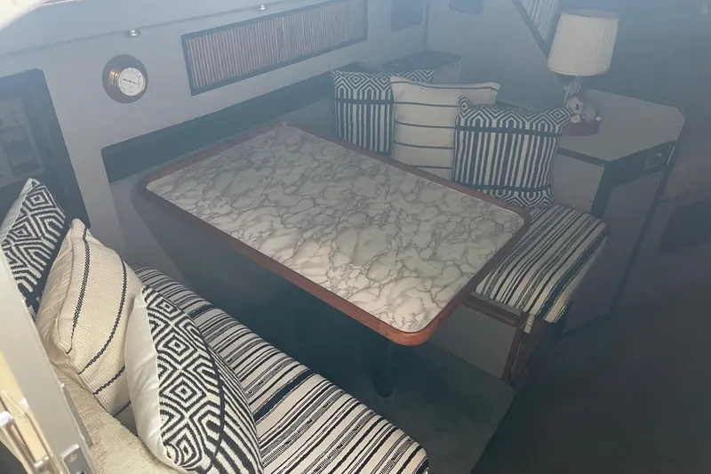 Slide: The Image of 1988 Sea Ray 300 Weekender cabin interior with striped cushions and marble-patterned table. - 20