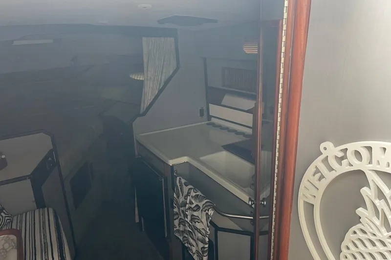 Slide: The Image of Interior of 1988 Sea Ray 300 Weekender boat with seating, table, and kitchenette. - 22