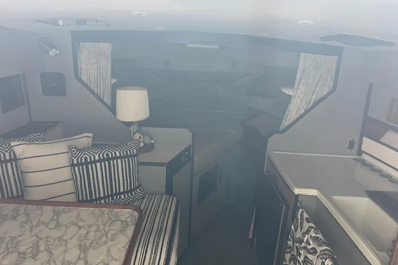 Slide: The Image of Interior of 1988 Sea Ray 300 Weekender boat with cozy sleeping area and lamp. - 23