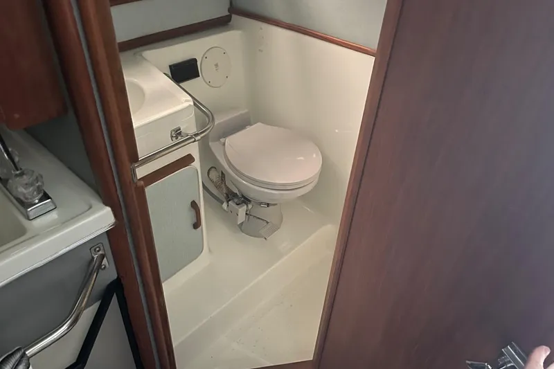 Slide: The Image of Interior of 1988 Sea Ray 300 Weekender bathroom with sink, mirror, and artwork. - 31