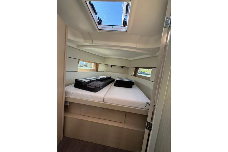 Slide: The Image of 2023 Beneteau Oceanis 38.1 cabin interior with skylight and neatly arranged bedding. - 11