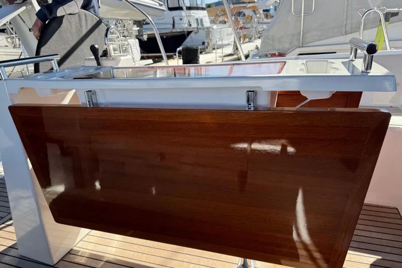 Slide: The Image of 2023 Beneteau Oceanis 38.1 yacht cockpit with wooden table and sleek design. - 5