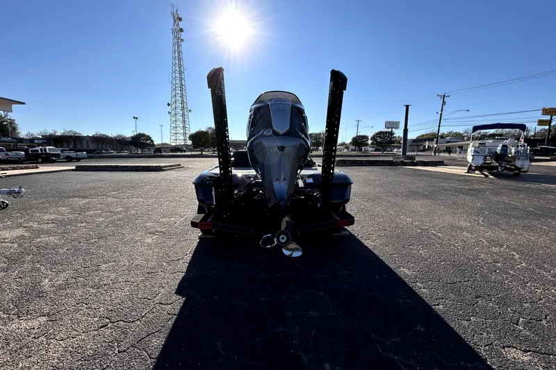Slide: The Image of 2026 Skeeter ZXE21 boat rear view under bright sun in parking lot. - 5