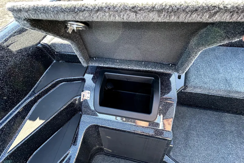 Slide: The Image of Open storage compartment in 2026 Skeeter ZXE21 boat, featuring carpeted interior and secure latch. - 23