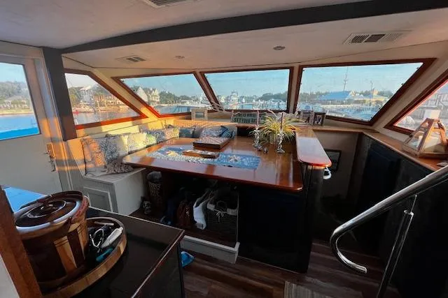 Slide: The Image of 1989 Hatteras 70 Cockpit Motor Yacht interior with panoramic windows and elegant seating area. - 12