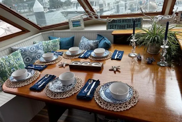 Slide: The Image of Elegant dining setup on 1989 Hatteras 70 Cockpit Motor Yacht, featuring nautical-themed decor. - 13