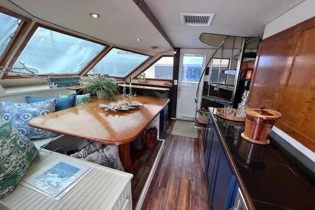 Slide: The Image of Interior of 1989 Hatteras 70 Cockpit Motor Yacht with elegant dining area and wooden accents. - 17