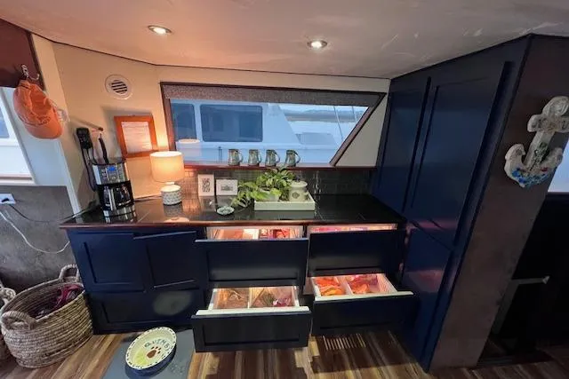 Slide: The Image of Interior of 1989 Hatteras 70 Cockpit Motor Yacht with open kitchen drawers and modern decor. - 21