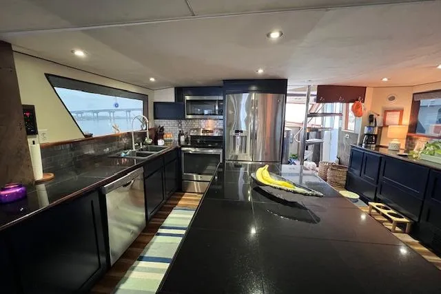 Slide: The Image of Luxurious kitchen interior of 1989 Hatteras 70 Cockpit Motor Yacht with modern appliances. - 23