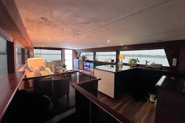 Slide: The Image of Luxurious interior of 1989 Hatteras 70 Cockpit Motor Yacht with modern furnishings and panoramic windows. - 9